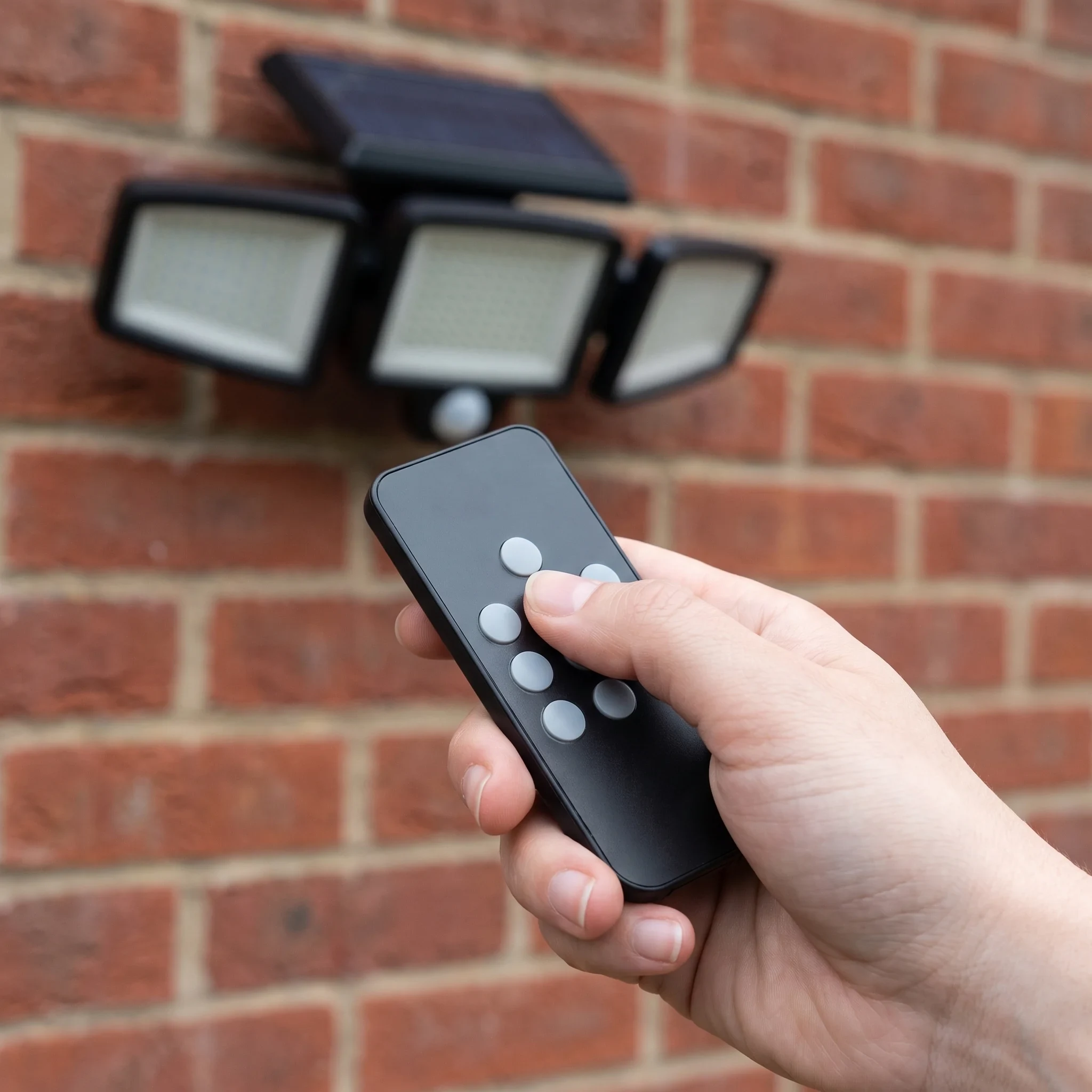 A hand using the wireless remote to change the light's mode