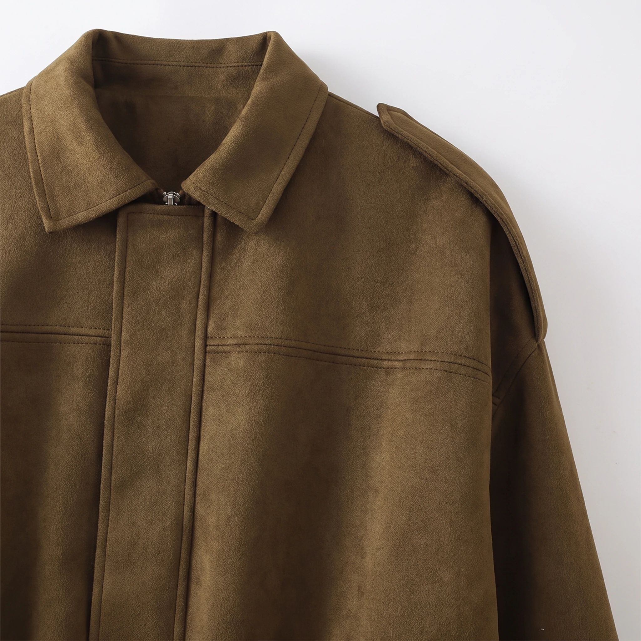 Close view of the collar, zip and shoulder tab on the camel suede-look jacket